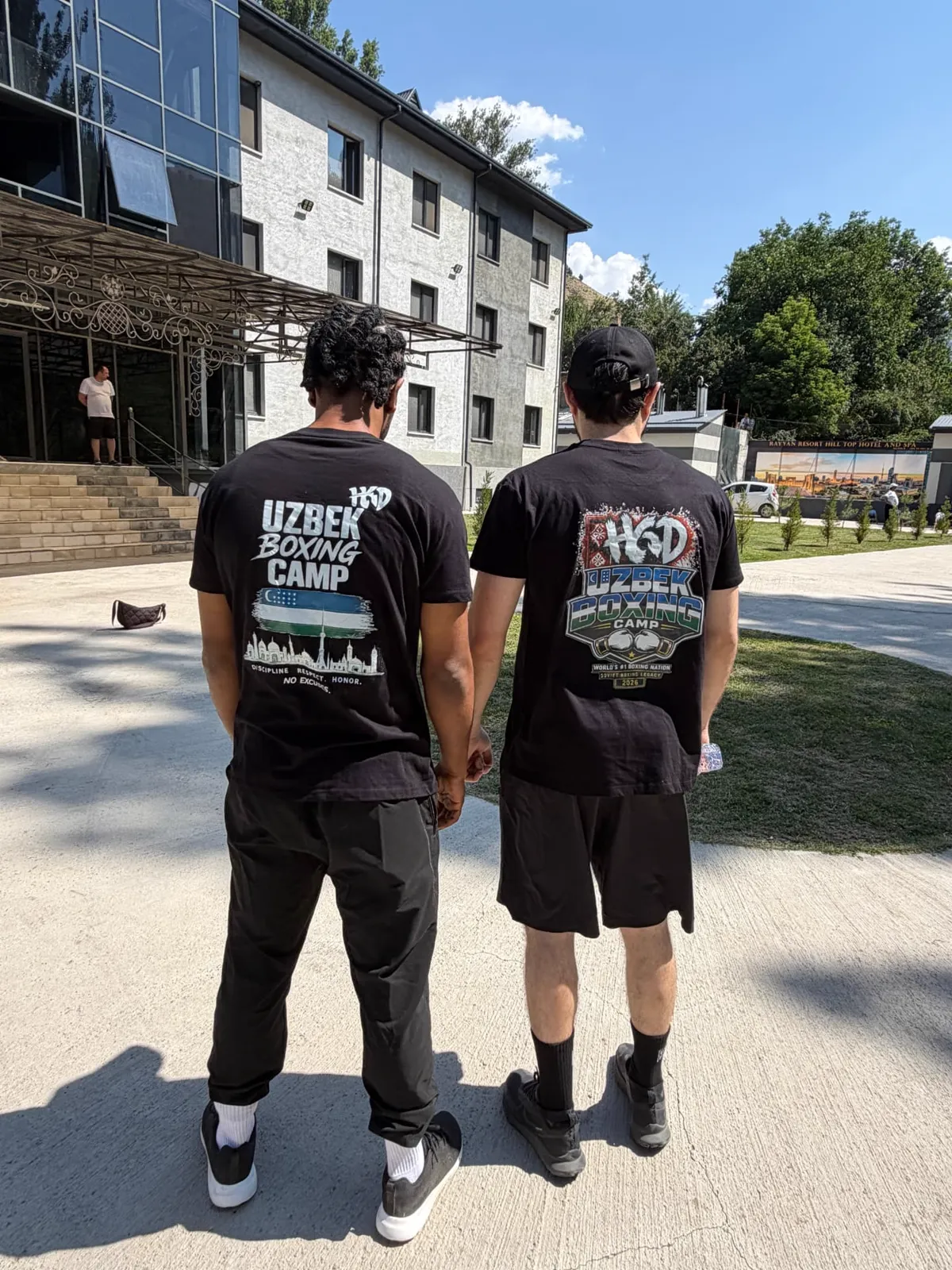 Athletes wearing Uzbek Boxing Camp t-shirts outside the mountain hotel